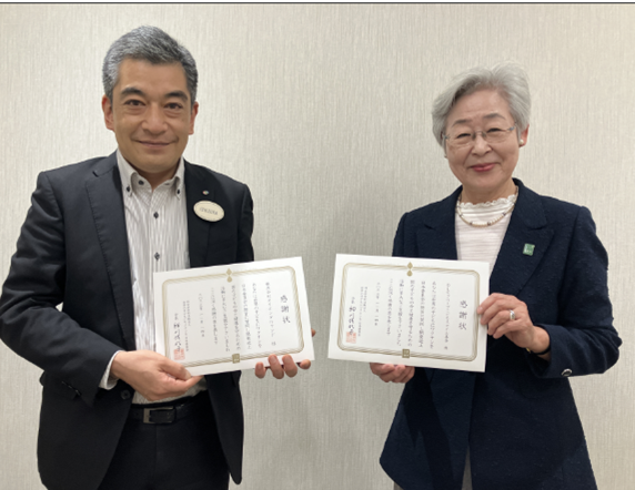 感謝状を贈呈する「世界の子どもにワクチンを 日本委員会」の剱持理事長（右）と、受け取る「OLCグループこどもスマイル基金」石塚事務局長（左）